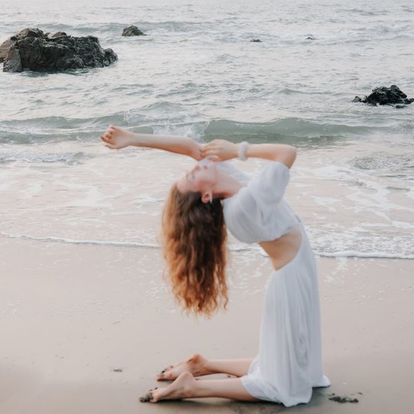 Woman stretching gracefully during a sunrise yoga session outdoors.